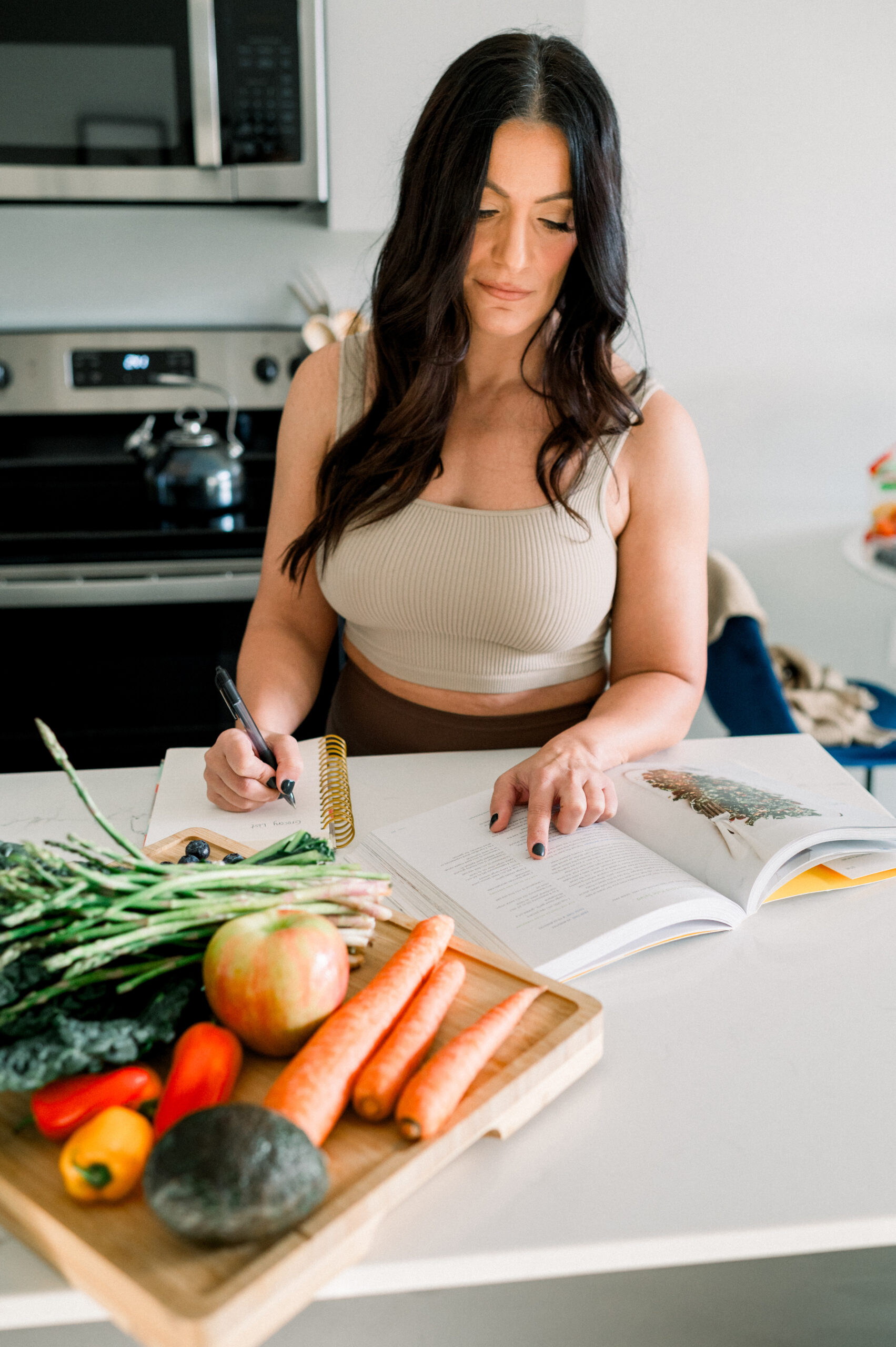 woman in kitchen with a variety of vegetables