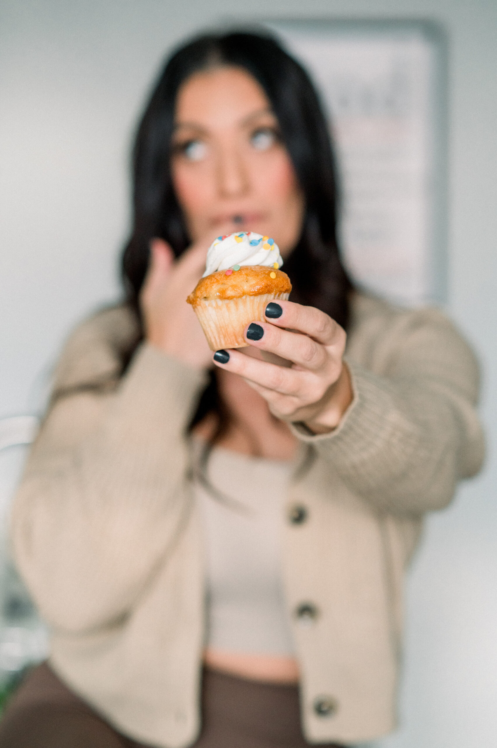 woman holding cupcake eating frosting